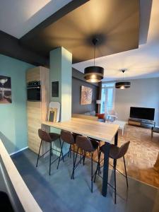 a dining room with a wooden table and chairs at Les Quatre Piliers - 1 min Palais Jacques Cœur in Bourges