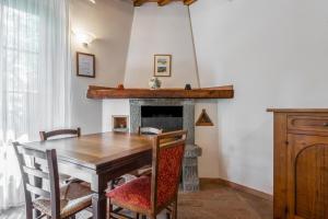 a dining room with a table and a fireplace at Podere Mezzastrada in Fiano