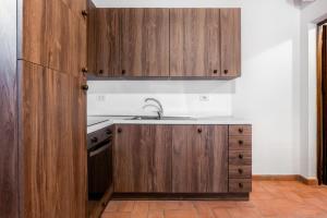 una cocina con armarios de madera y fregadero en Podere Mezzastrada, en Fiano