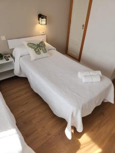 La Pueblanueva的住宿－Hostal Restaurante CASA FRAN，一间卧室配有两张带白色床单和镜子的床