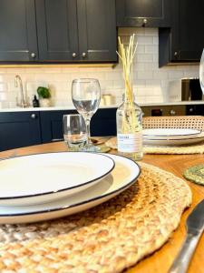 a table with a plate and two wine glasses on it at Georgian boutique apartment in central Bath in Bath