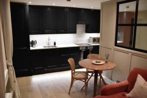 a kitchen with a table and a kitchen with black cabinets at Georgian boutique apartment in central Bath in Bath