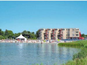 een groep mensen op een strand en een gebouw bij Appartement Zuiderzeestate Makkum in Makkum