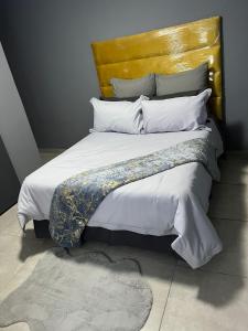 - un grand lit avec une tête de lit et des oreillers en bois dans l'établissement Ubuntu Lifestyle Estate, à Krugersdorp
