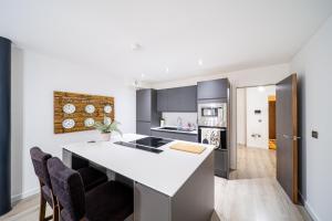 a kitchen with a large white island in a room at Exclusive 2 Bedroom Penthouse in Bradford City Centre in Bradford