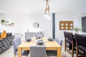 a dining room with a wooden table and chairs at Exclusive 2 Bedroom Penthouse in Bradford City Centre in Bradford