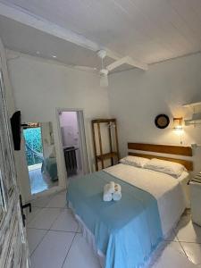 a bedroom with a bed with two towels on it at Céu Azul Pousada in Arraial d'Ajuda