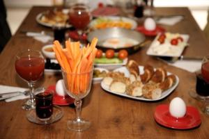 a wooden table with plates of food and eggs and carrots at Ece Han Butik Otel in Atakum