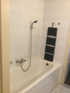 een badkamer met een bad en een douche bij Appartement Zuiderzeestate Makkum in Makkum