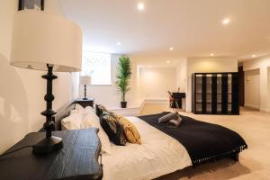 a bedroom with a large bed with a lamp at Camber Hill - Long Stay Offer in London