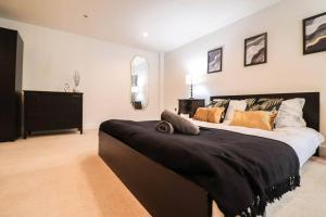 a bedroom with a large bed with pillows on it at Camber Hill - Long Stay Offer in London