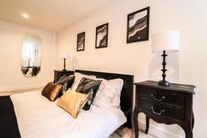 a bedroom with a bed with a black dresser and a lamp at Camber Hill - Long Stay Offer in London
