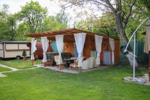 a pavilion with a table and chairs in a yard at House Garden in Turda