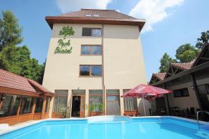 un hôtel avec une piscine en face d'un bâtiment dans l'établissement Park Hotel Gyula, à Gyula