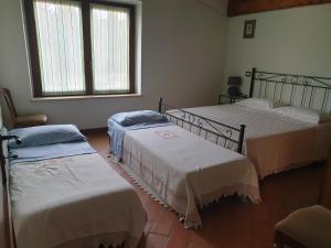 a room with three beds and a window at La Fornace in Rapolano Terme