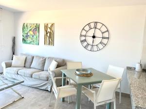 a living room with a couch and a clock on the wall at Mojacar Espectaculares Vistas al Mar in Mojácar