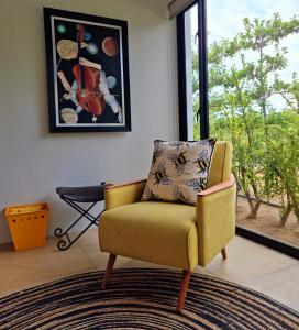 uma cadeira amarela numa sala de estar com uma janela em Klawerjas em Robertson