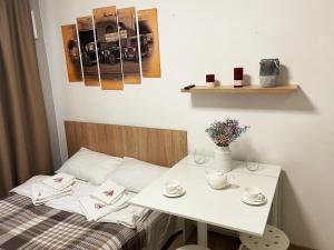 uma cama com uma mesa branca e uma mesa com copos em MYFREEDOM Апартаменти метро Академмістечко ТЦ Lavina Mall em Kiev