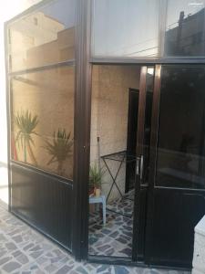 an open glass door of a building with potted plants at Duraidi in Amman