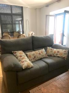 un sofá gris con almohadas en la sala de estar en 2 bedrooms apartement with city view balcony and wifi at Ciudad Real, en Ciudad Real