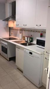 una cocina con armarios blancos y fregadero en 2 bedrooms apartement with city view balcony and wifi at Ciudad Real, en Ciudad Real