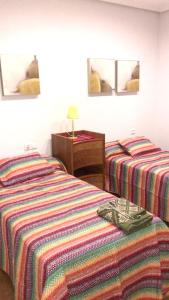 a hotel room with two beds and a night stand at 2 bedrooms apartement with city view balcony and wifi at Ciudad Real in Ciudad Real