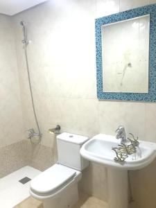 a bathroom with a white toilet and a sink at 2 bedrooms apartement with city view balcony and wifi at Ciudad Real in Ciudad Real