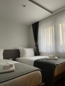 Habitación de hotel con 2 camas y ventana en Etnomania Boutique Hotel en Pristina