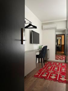 a room with a desk and a chair and a red rug at Etnomania Boutique Hotel in Pristina