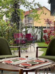 um pátio com cadeiras e uma mesa num quintal em Etnomania Boutique Hotel em Pristina