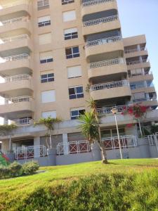 a tall building with a palm tree in front of it at 3 bedrooms apartement with sea view shared pool and furnished garden at Aguilas in Águilas