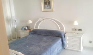 a bedroom with a blue bed and two night stands at 3 bedrooms apartement with sea view shared pool and furnished garden at Aguilas in Águilas