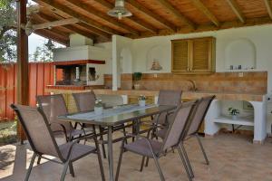 a table and chairs on a patio with a kitchen at ZeusPlace Olympus Olive Country House 4 in Leptokaria