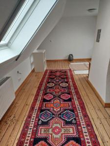 an attic room with a rug on the floor at Ferienwohnung Lojane in Kranenburg