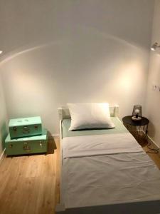 een kleine slaapkamer met een bed en een groene koffer bij Appartement de 2 chambres avec vue sur la ville terrasse amenagee et wifi a Houlgate a 1 km de la plage in Houlgate