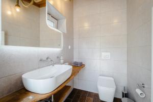 a white bathroom with a sink and a toilet at Kritamos Luxury Apartment in Chrysi Ammoudia +12 photos