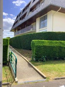 een gebouw met een groen hek ervoor bij Appartement de 2 chambres avec vue sur la ville terrasse amenagee et wifi a Houlgate a 1 km de la plage in Houlgate