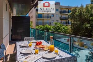 una mesa con comida y zumo de naranja en el balcón en Un'Estate al Mare Palamós, en Palamós