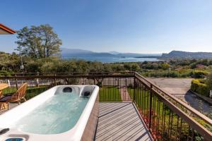 a hot tub on a balcony with a view of the water at Casa Veronica in Manerba del Garda