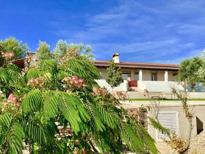 a house with trees and flowers in front of it at 3 bedrooms villa with shared pool enclosed garden and wifi at Casais de Sao Bras in Casais de São Brás