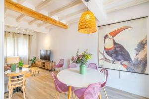 Casa Bardena Negra, cómodo alojamiento para visitar las Bardenas y Sendaviva في Fustiñana: غرفة طعام مع طاولة بيضاء وكراسي أرجوانية