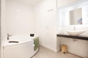 a white bathroom with a sink and a toilet at Altabib Riad in Córdoba