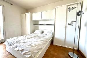 Bright and spacious cocoon with sea view في أجاكسيو: غرفة نوم بيضاء مع سرير وخزانة