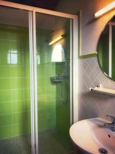 zieloną łazienkę z prysznicem i umywalką. w obiekcie Cal Perdigués de Boada w mieście Boada