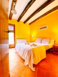 ein Schlafzimmer mit gelben Wänden und einem großen Bett in der Unterkunft Cal Perdigués de Boada pet friendly in Boada + 14 Fotos