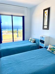 two beds in a room with a view of the ocean at Mojacar Espectaculares Vistas al Mar in Mojácar