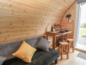 a living room with a couch and a wooden wall at Parys Pod in Bodewryd