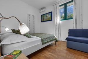 a bedroom with a bed and a blue chair at Villa Rita in Makarska