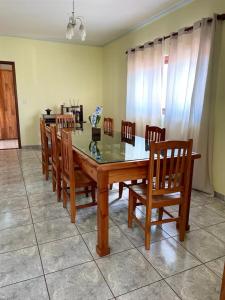 a dining room table with wooden chairs and a glass top at Pousada Cabana in Avaré