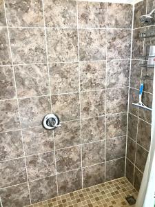 a bathroom with a shower with a tile wall at Sea Haven - Sea View at Symphony Beach Club in Ormond Beach +16 photos
